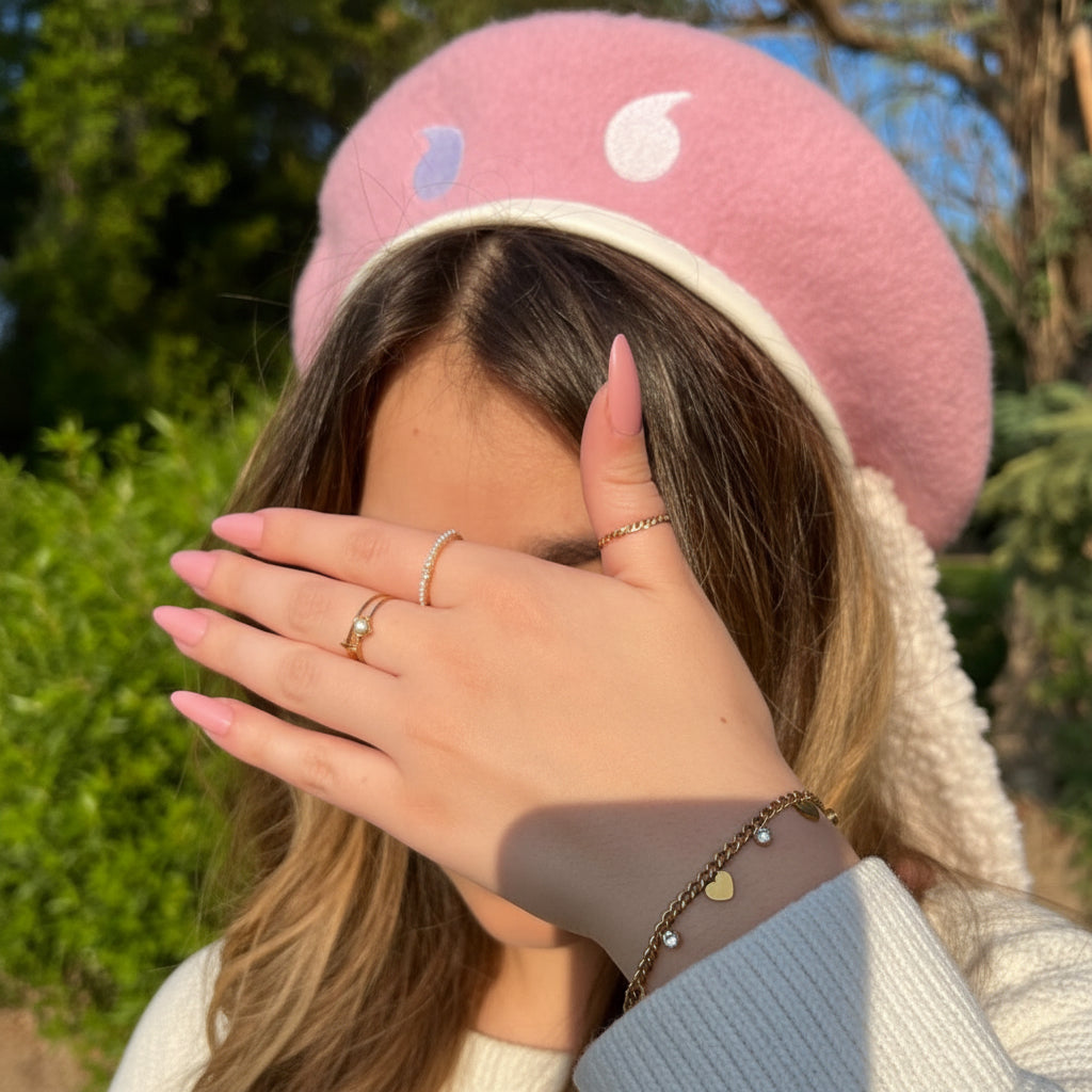 Person wearing a pink beanie with colorful patterns outdoors