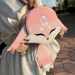 Person wearing a pink and white backpack with floral designs outdoors.