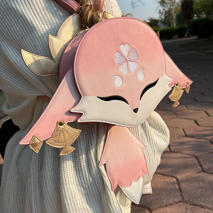 Person wearing a pink and white backpack with floral designs outdoors.