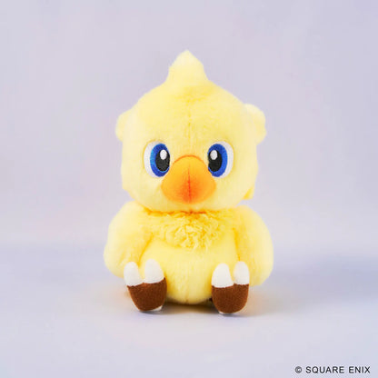 A yellow plush toy chick with large blue eyes, an orange beak, and brown-and-white feet, centered on a light gray studio background. A small Square Enix copyright mark appears in the bottom right corner.