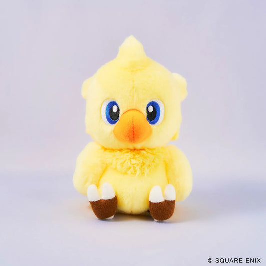A yellow plush toy chick with large blue eyes, an orange beak, and brown-and-white feet, centered on a light gray studio background. A small Square Enix copyright mark appears in the bottom right corner.
