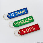 Three keychains labeled 'TANK', 'HEALER', and 'DPS' on a light gray background.