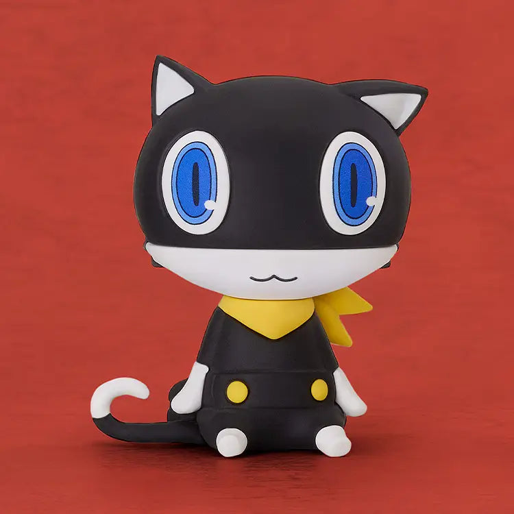 Black cat-shaped figurine with blue eyes and a yellow collar on a red background