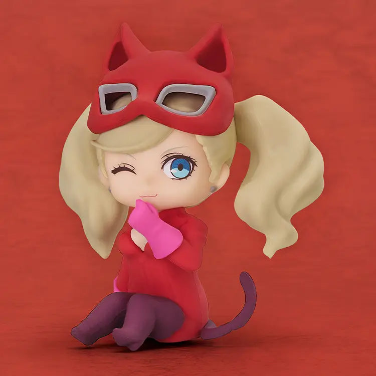 Toy figure of a character with a red mask and outfit on a red background