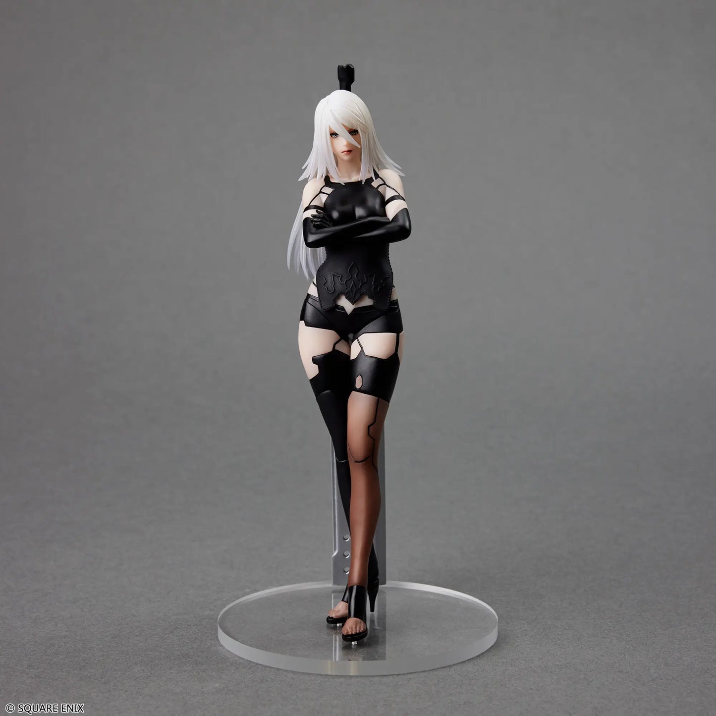 Action figure of a character in black and white attire on a gray background