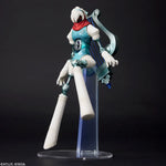 A stylized articulated action figure of a sci-fi female character posed on a clear acrylic display stand against a dark studio background. The figure has white hair, a red scarf, a teal and white bodysuit, and a large curved silver weapon accessory.