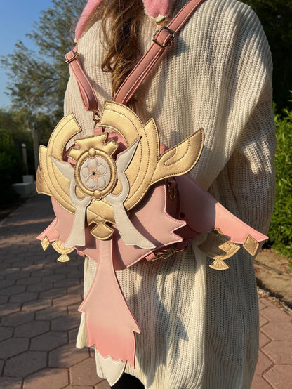 Person wearing a decorative pink and gold bag with a unique design.