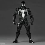 Marvel Venom action figure in a dynamic standing pose, featuring a glossy black symbiote suit with a white chest emblem and large white eyes, photographed against a dark gray studio background.